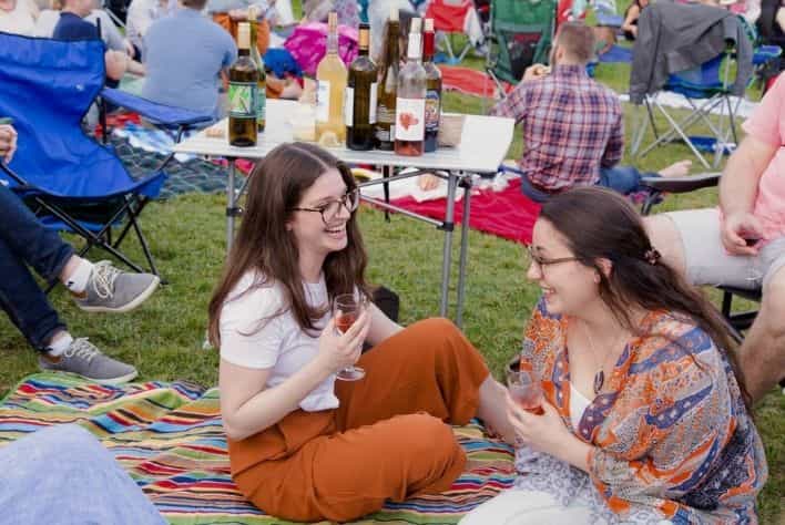 Two women sitting and enjoying a glass of wine at the Mount Vernon Wine Festival.
